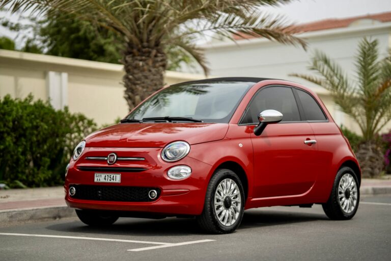 Charming red Fiat 500 Cabrio 2023 for rent in Dubai offering a stylish compact design fun open-top driving experience and modern features for city exploration