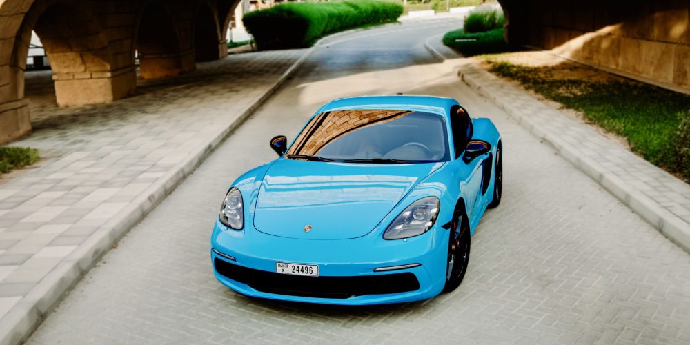 Sporty Miami Blue Porsche Cayman S for rent in Dubai offering thrilling performance sleek design and a luxurious driving experience