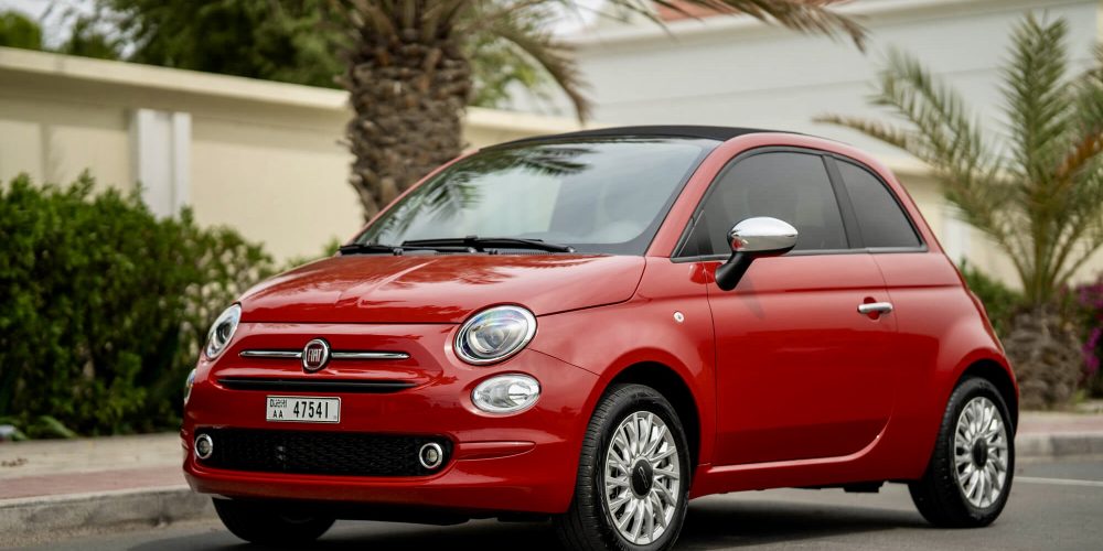 Charming red Fiat 500 Cabrio 2023 for rent in Dubai offering a stylish compact design fun open-top driving experience and modern features for city exploration