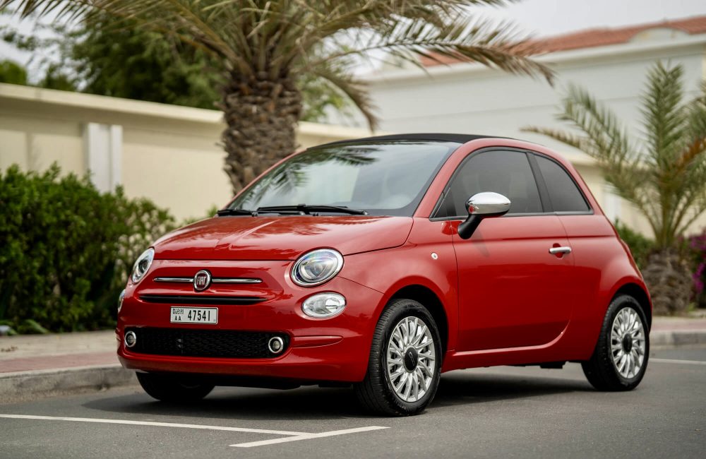 Charming red Fiat 500 Cabrio 2023 for rent in Dubai offering a stylish compact design fun open-top driving experience and modern features for city exploration