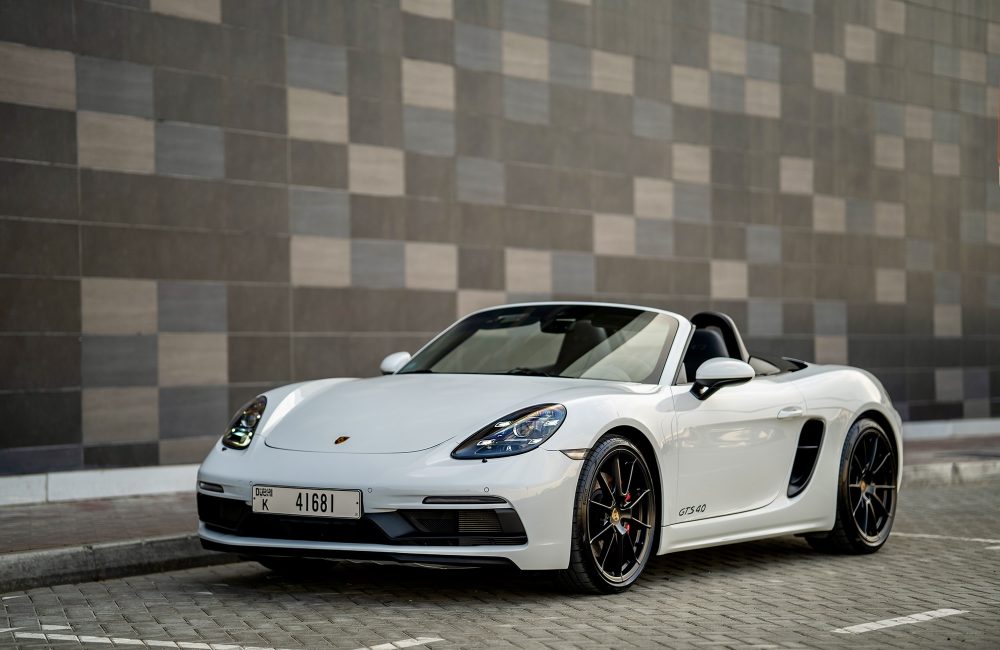 Elegant white Porsche Boxster GTS for rent in Dubai offering a thrilling open-top driving experience with high-performance engineering sleek design and advanced technology